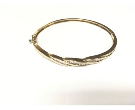 A gold bangle with 25 diamonds.