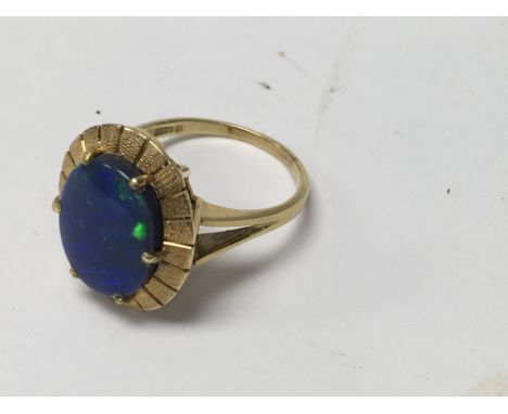 An unmarked gold ring inset with Opal coloured stone size Q .