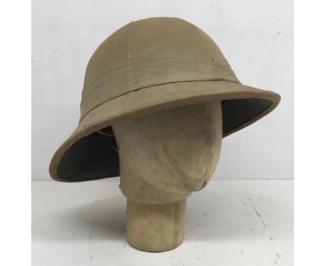 A WW2 era British Wolseley Pattern pith helmet, dated 1942 and broad arrow marked to the leather headband. Manufactured by Fa