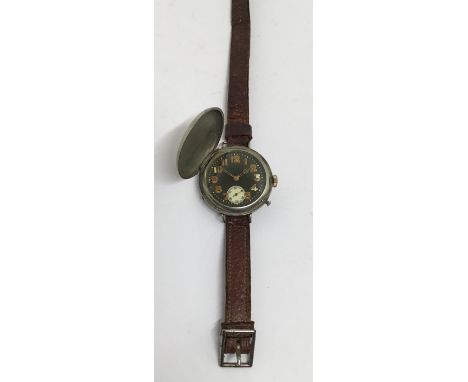 A WW1 era trench wristwatch, with original leather strap, dated Christmas Day 1916. Nickel casing, with push button release t