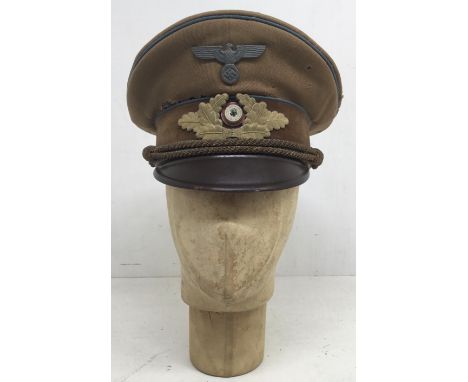A WW2 era German Orts level political leader visor cap. Tan coloured crown with blue piping to indicate Ortsgruppe level. Pol