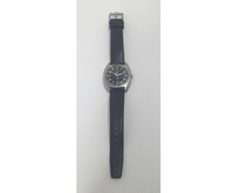 A British Army issue Hamilton wristwatch, dated 1975 to the back cover. Usual barrel shaped, with black dial and luminescent 