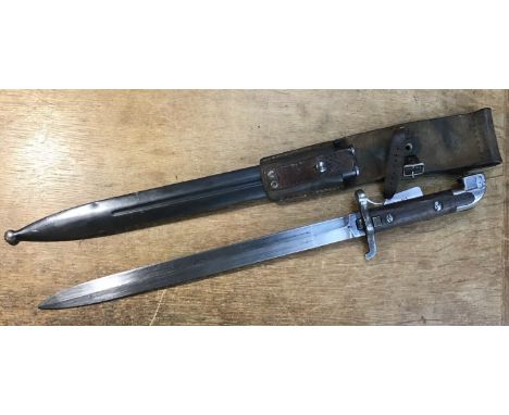 A Swedish M1914 Mauser bayonet, complete with scabbard and leather frog. With curved wooden slab grips, curved morticed pomme