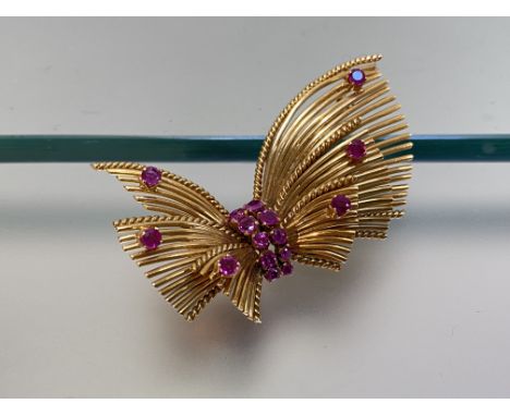 A ruby-set 18ct gold brooch, the Modernist spray form set to the centre with a double row of pink ruby points, a further six 