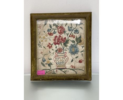 A silk needlework panel, probably 18th century, worked in coloured threads with issuing carnations and other scrolling flower