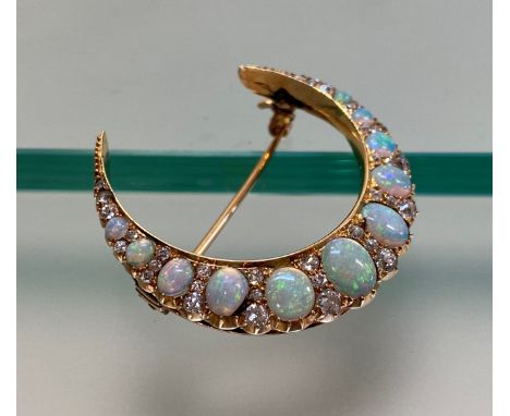 A late 19th century opal and diamond crescent brooch, set with nine oval-cut graduated opals spaced by graduated round brilli