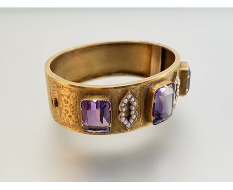 A late 19th century amethyst and seed pearl set hinged cuff bangle, the three large graduated emerald-cut amethysts claw-set 