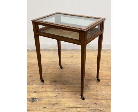 An Edwardian mahogany bijouterie table, with glazed hinged top above a glazed frieze, raised on square tapered supports with 