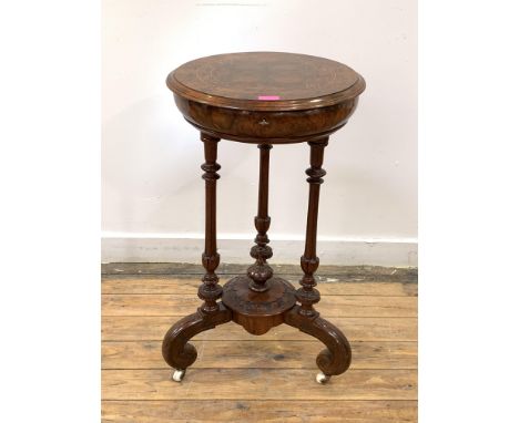 A Victorian figured walnut work table, the circular boxwood-strung top lifting to reveal satinwood-lined interior fitted with