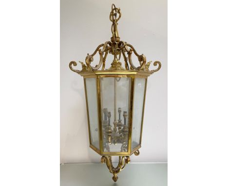 A large gilt-brass hall lantern, the tapering hexagonal frame inset with six bevelled glass panels enclosing six electrified 