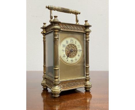 A late 19th century brass carriage clock, the four-glass case with fluted columns and cast with bands of blind flowerhead tre