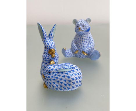 Two Herend porcelain animal models in the blue fishnet pattern, highlighted with gilding: the first a pair of rabbits; the se