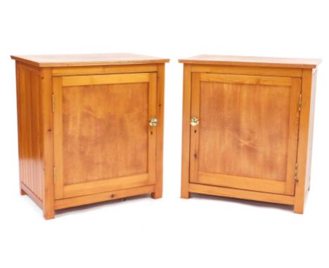 A pair of pine bedside cabinets, each rectangular top above a panelled door enclosing single shelf, on stiles, 70cm high, 65c