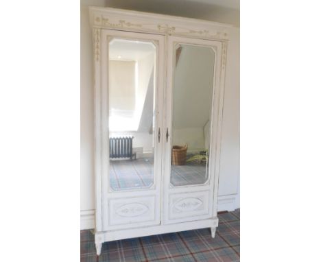 A 20thC Continental painted oak armoire, the top with a moulded edge above a carved frieze decorated with urn flanked by bows