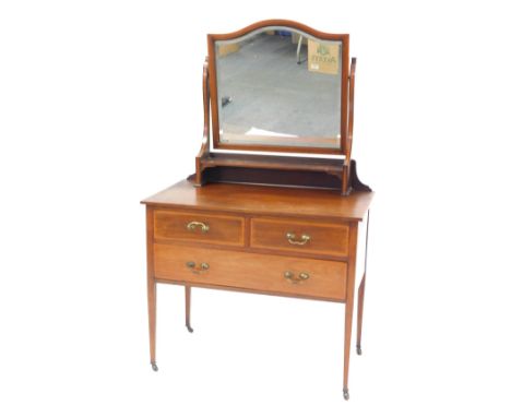 An Edwardian mahogany and cross banded dressing chest, the bevelled shaped mirror above a shelf, the base with two short and 