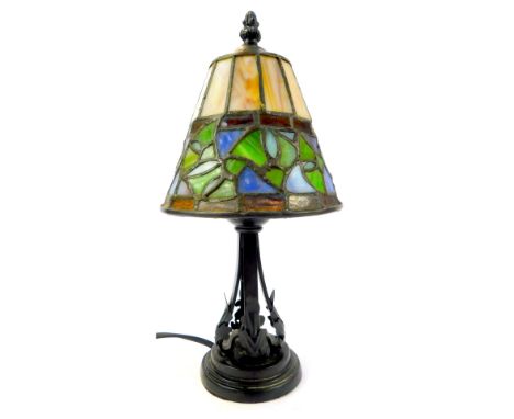 A Tiffany style table lamp, the leaded glass shade of tapering circular form, decorated in green, blue and cream, on a cast m