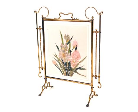 A late Victorian brass and glass panelled fire screen, with scroll framework supports and a painted glass panel of lilies, 76