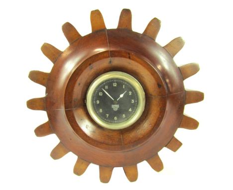 A WW1 propeller shaft Smiths mantel clock, with circular dial bearing black Arabic numerals, quartz movement, the case carved