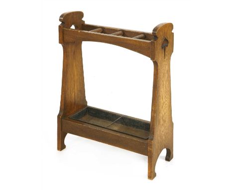 An Arts and Crafts oak stick stand, with fret cut sides, four divisions, with a metal liner, 56cm wide 25cm deep 73.5cm high