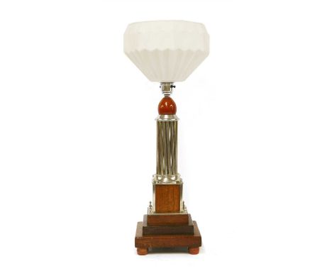 An Art Deco silvered and mahogany table lamp, with a moulded white shade, a silvered multi-column support, raised on a steppe