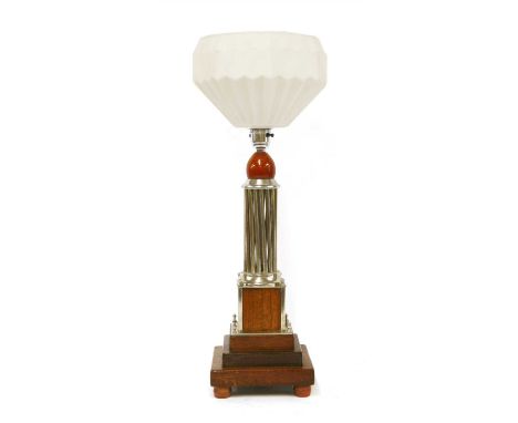 An Art Deco silvered and mahogany table lamp, with a moulded white shade, a silvered multi-column support, raised on a steppe