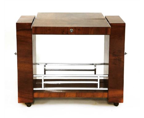 An Art Deco walnut drinks trolley, with a cantilever top folding from two tiers to a larger surface, with a shelf below, a ch