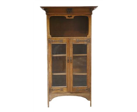 An oak bookcase, with a wide cornice over an open shelf, a glazed cupboard below with decorative copper hinges, 170cm wide 40