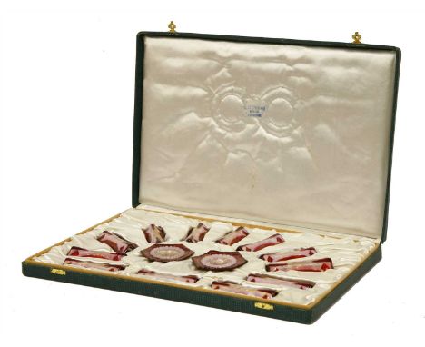 A Limoges enamel table set, designed by Marylou Fauvet, comprising twelve knife rests and two salts, in pink and red enamels,