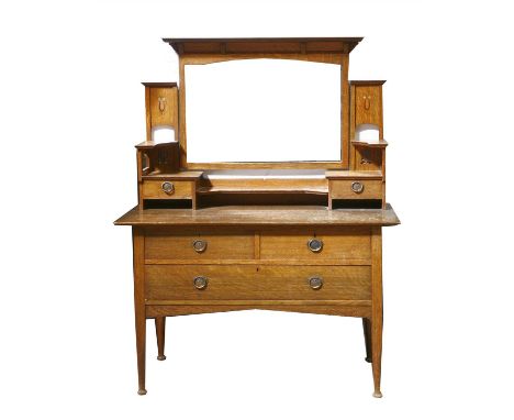 An oak dressing table, the rectangular mirror plate flanked with inlaid and pierced panels, with a central shelf and drawers,