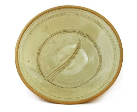 *Richard Batterham (b.1936), a monumental stoneware charger, with a pale green glaze, with combed rings and wipe to the centr