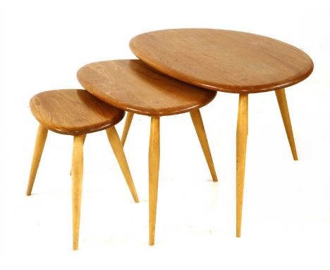 An Ercol 'Pebble' nest of three tables, the shaped tops on tapering supports, labelled, largest 65cm wide 44cm deep 40cm high