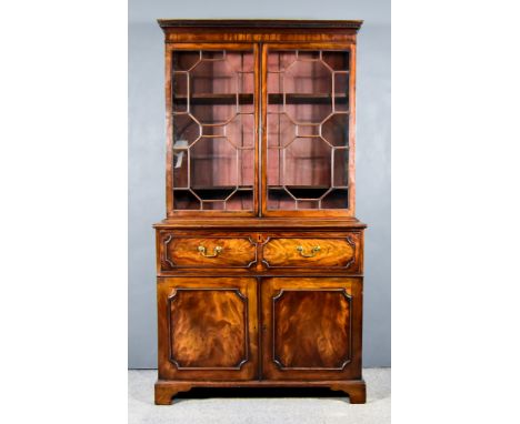 A George III Mahogany Secretaire Bookcase, the upper part with dentil moulded cornice, fitted two shelves enclosed by a pair 