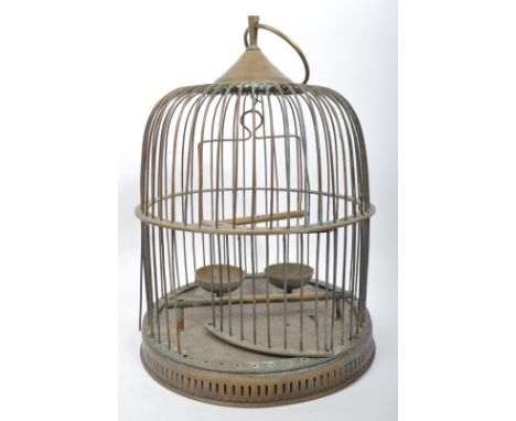 An early 20th century brass dome shaped birdcage with hanging ring, feeding bowl and accessories. It measures approx. 40cm ta
