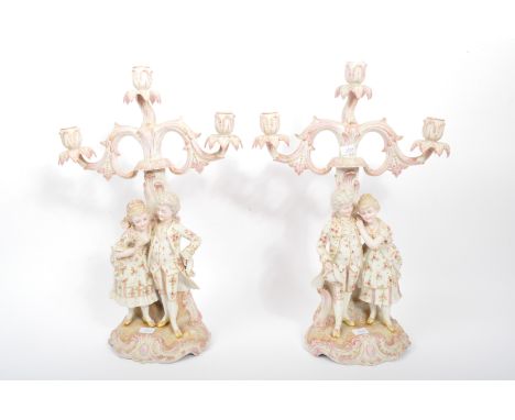 A pair of 19th century German bisque / porcelain Sitzendorf manner candelabras in the manner of two courting couples in Regen