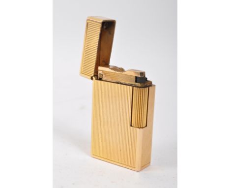 A vintage 20th century S T Dupont French gold plated pocket lighter with rigged patterns throughout. It measures approx. 5.5 