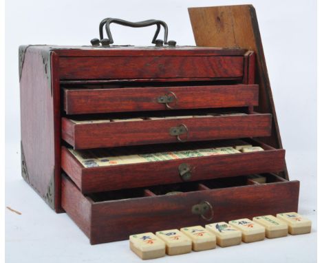 An early 20th century Chinese Mahjong game set. Held within a wooden shelved carry box with painted bamboo and bone counters.