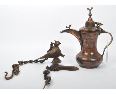 An early 20th century Turkish Middle Eastern copper dallah coffee pot having incised decoration and cast metal bird finials t