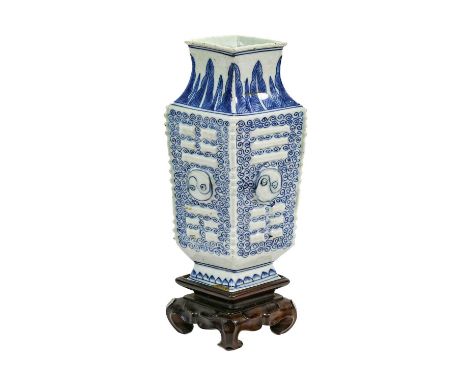 A Chinese Porcelain Lozenge Shaped Vase, Qing Dynasty, 18th century, moulded with symbols on an underglaze whorl ground withi