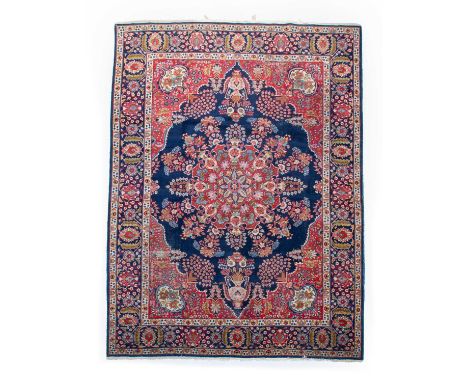 Tabriz Carpet Iranian Azerbaijan, circa 1950The indigo field centred by a scarlet floral medallion framed by spandrels and in