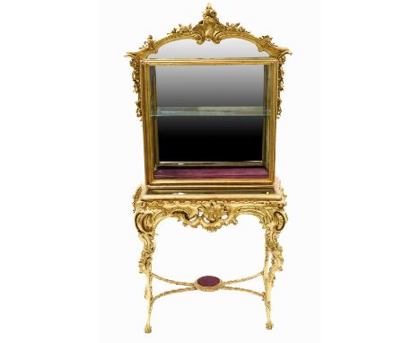 A Victorian Gilt and Gesso Display Cabinet, 3rd quarter 19th century, the upper section with a mirrored back surmounted by a 