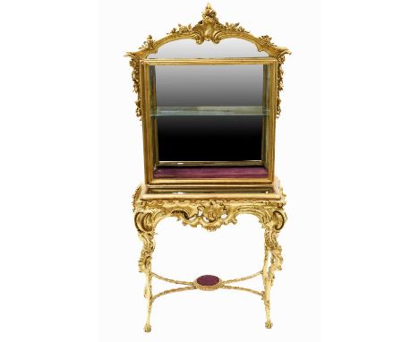 A Victorian Gilt and Gesso Display Cabinet, 3rd quarter 19th century, the upper section with a mirrored back surmounted by a 