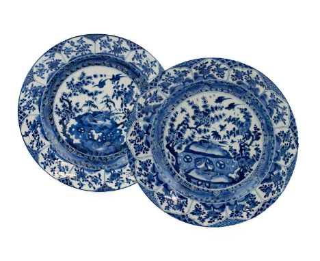 A Pair of Chinese Porcelain Circular Dishes, Kangxi, painted in underglaze blue with birds amongst prunus and rockwork within