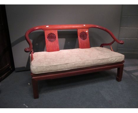 A Chinese hard wood bench with carved back and cushion seat, 130cm wide  