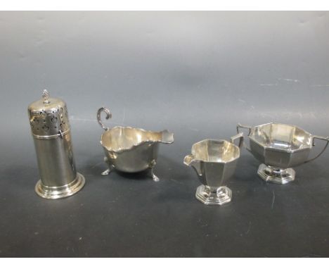 An Edwardian silver sauceboat, 6ozt, a silver two piece tea service of faceted form comprising cream jug and sugar bowl, 9.5o