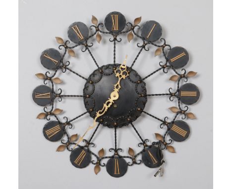 A Junghans mid century wrought metal wall clock with Roman numeral markers and gilt hands.  Working, with key.