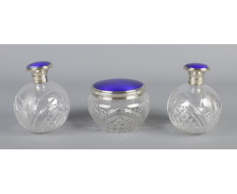 A silver topped and blue enamel cut glass three piece dressing table set, consisting of powder bowl and two matching globular