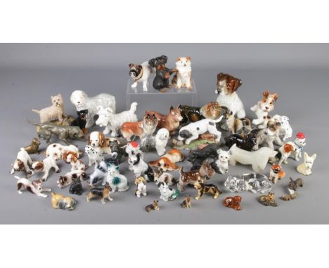 A large quantity of dog figurines including ceramic, composite and metal examples.