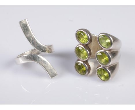 A silver Gucci twist ring, together with a large silver dress ring, set with six peridots. Sizes Q and N.