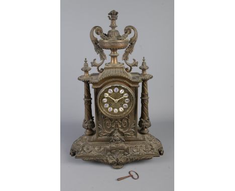 A 19th century Henry Marc of Paris French metal mantel clock featuring Roman numeral markers, urn finial and column supports.