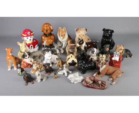 A large quantity of dog figurines including ceramic and composite examples.